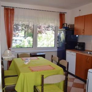 a kitchen with a table with a green table cloth at Magdaléna Holiday Home in Zalakaros