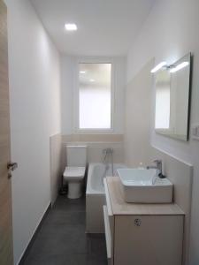 łazienka z umywalką, toaletą i oknem w obiekcie Disfruta - Enjoy Valencia Ruzafa w Walencji