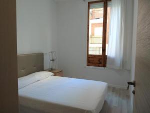 a white bedroom with a bed and a window at Disfruta - Enjoy Valencia Ruzafa in Valencia