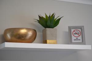 a shelf with a potted plant and a no smoking sign at Columbine Place in Durbanville