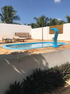 a swimming pool with a blue fountain in the middle at Apê do Fabiano in Jericoacoara