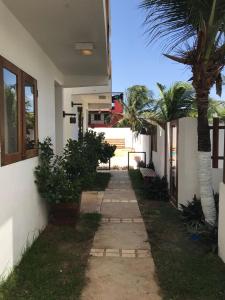 a walkway in front of a house with a palm tree at Apê do Fabiano in Jericoacoara