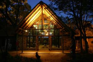 a glass house with a triangular roof at night at Kedar Heritage Lodge, Conference Centre & Spa in Phokeng