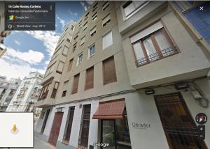 un edificio en una calle de la ciudad con un cartel delante en Disfruta - Enjoy Valencia Ruzafa, en Valencia