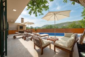 an outdoor patio with chairs and an umbrella at Villa Nika in Bisko