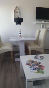 ein Wohnzimmer mit einem weißen Tisch und Stühlen in der Unterkunft Südstrandflair in Fehmarn