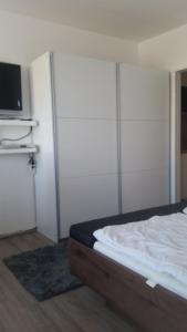 ein Schlafzimmer mit einem Bett und einem TV an der Wand in der Unterkunft Südstrandflair in Fehmarn