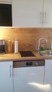 eine Küche mit einem Waschbecken und einem Laptop auf der Theke in der Unterkunft Südstrandflair in Fehmarn