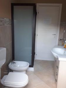 a bathroom with a toilet and a sink at La Casa Dei Colori in Zafferana Etnea