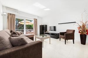 a living room with a couch and a chair at Victory Village 9F in Quinta do Lago