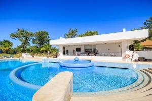 a swimming pool in front of a house at Victory Village 9F in Quinta do Lago