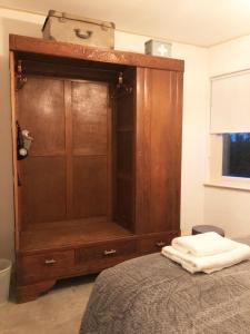 a large wooden cabinet in a bedroom with a bed at The Old Garage in Tilburg