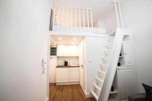 eine weiße Treppe in einem kleinen Zimmer mit einer Küche in der Unterkunft Saint Philip in Krakau