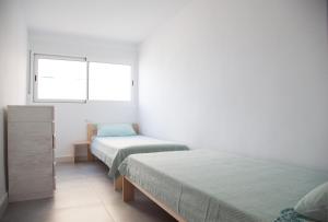 ビリャホヨサにあるBeachfront apartmentのベッドルーム1室(ベッド2台、窓付)