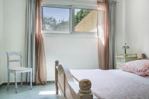 a bedroom with a bed and a window and a chair at Villa Pilali in Kefallonia