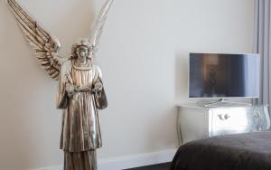 a statue of an angel standing next to a bed at König`s Hotel am Schlosspark in Rheda-Wiedenbrück