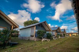 una fila de casas con sillas en el patio en Cabañas Henua Iti, en Hanga Roa