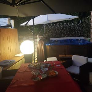 einen Tisch mit Teller mit Lebensmitteln und einem Regenschirm in der Unterkunft Le clos Fleury Cluny in Cluny