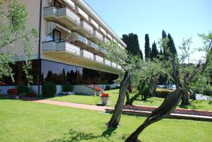 un edificio con un albero di fronte a un edificio di Hotel Désirée - Garda Lake Collection a Sirmione