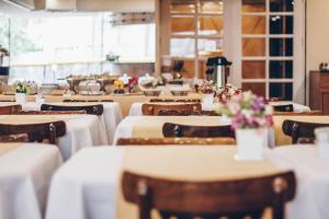 a dining room with tables and chairs with flowers on them at Tower Icaraí Hotel in Niterói