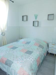 a bedroom with a bed with a quilt on it at Le petit nid in Lourdes