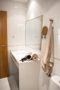 biała łazienka z umywalką i lustrem w obiekcie MerieElisabethSunApartment w Corralejo