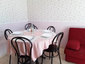 ルッカにあるAppartamento Elenaのダイニングルームテーブル(ピンクのテーブルクロス、椅子付)