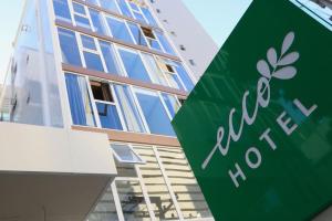 a green sign in front of a building at Ecco Hotel Fortaleza in Fortaleza