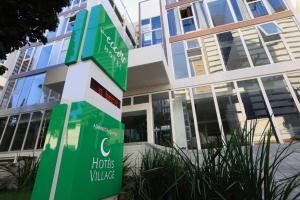 a green sign in front of a building at Ecco Hotel Fortaleza in Fortaleza