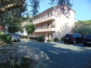 a building with cars parked in front of it at Appartamento il Geranio in Quercianella