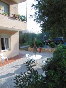 a patio with a table and chairs next to a building at Appartamento il Geranio in Quercianella