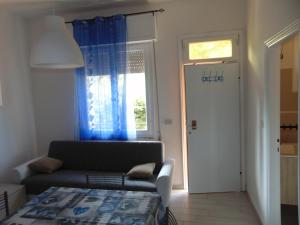 a living room with a couch and a window at Appartamento il Geranio in Quercianella