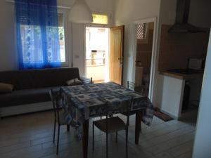 a living room with a table and chairs and a couch at Appartamento il Geranio in Quercianella