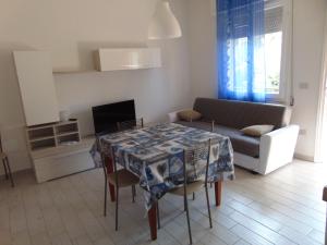 a living room with a table and a couch at Appartamento il Geranio in Quercianella