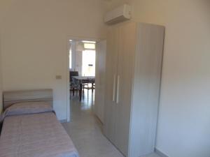 a room with two beds and a closet and a table at Appartamento il Geranio in Quercianella