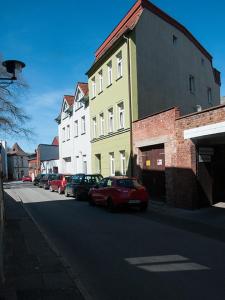 eine Straße mit Autos, die vor einem Gebäude geparkt sind in der Unterkunft Haus Wallstraße in Wismar