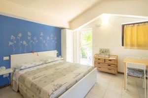 1 dormitorio con 1 cama con pared azul en Country House Villa Sabrina, en San Ginesio