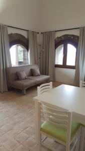 a living room with a couch and a table and chairs at Dammusi di pietra Stella in Pantelleria