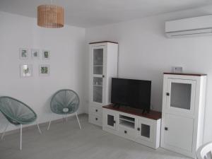 ein Wohnzimmer mit einem TV und 2 Stühlen in der Unterkunft Apartamento recién reformado y climatizado en ubicación inmejorable. in Peñíscola
