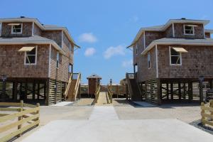 dois grandes edifícios de tijolos com um céu azul ao fundo em Whalebone Ocean Cottages by KEES Vacations em Nags Head