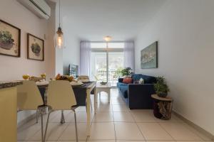 Una cocina y una sala de estar con una mesa y un sofá. en Mogan Beach | CarmitAtHome, en Puerto de Mogán