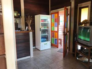 a living room with a refrigerator and a television at Pousada Arara Canindé in Sao Jorge
