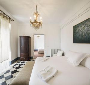 1 dormitorio con cama blanca y lámpara de araña en La Casa Grande de Zujaira en Zujaira