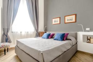 a bedroom with a bed with blue and purple pillows at La Terrazza di Roberta in Naples