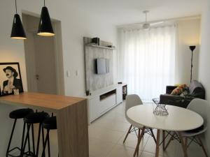 cocina y sala de estar con mesa y sillas en Apart TOP moderno e completo en Florianópolis