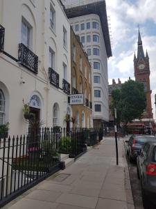 ロンドンにあるセントラル ホテルの錬鉄塀と時計塔のある街道