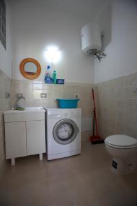 ein Badezimmer mit Waschmaschine und Toilette in der Unterkunft Villa Cecita in Sellia Marina