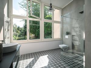 a bathroom with a tub and a toilet and a window at City Apartments Siegburg Studios in Siegburg