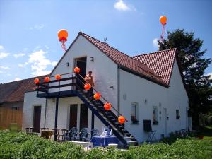 un homme debout sur une échelle sur une maison dans l'établissement Ferme Lenfant, à Ville-Pommeroeul