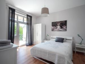 a white bedroom with a bed and a window at City Apartments Siegburg in Siegburg